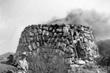 Charalambos Fatseas: Manolis Veneris, known as Koumaros (b.1929) in front of a working lime kiln. The kiln was between Agia Elessa and Drymonas. The island is dotted with now abandoned lime kilns, whose remains, like those of small towers, are usually found in scrubland so as to be close to...