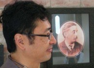 Bon Koizumi poses with a portrait of his great-grandfather, Lafcadio Hearn. ( 
