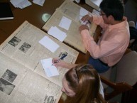 A pair of students are examining old Kytherian Newspapers, dating from the 1860's,  that are kept in the files of the Kytherian Association of Athens. 